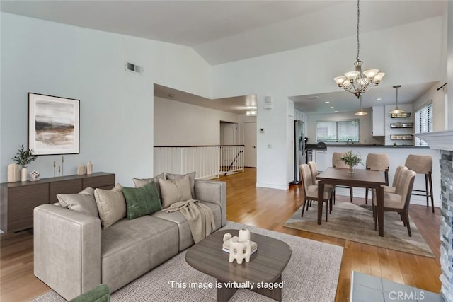 529 El Azul Cir, Oak Park, CA 91377 - living room with a chandelier, light wood-style flooring, and lofted ceiling
