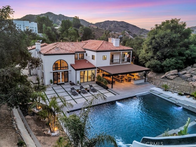 176 Saddlebow Rd, Bell Canyon, CA 91307 - back of house with a chimney, stucco siding, a mountain view, and a tiled roof