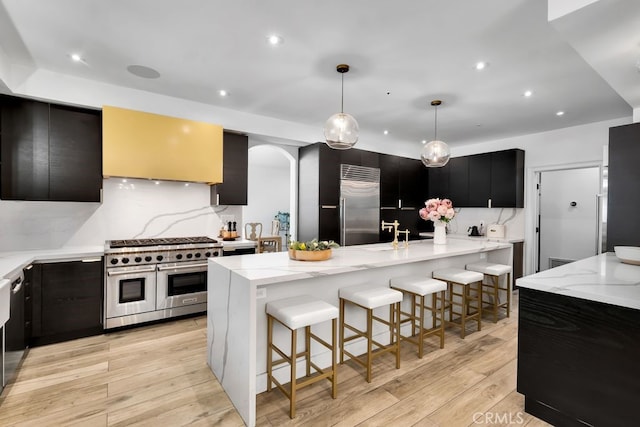 176 Saddlebow Rd, Bell Canyon, CA 91307 - kitchen with high quality appliances, dark cabinets, light wood-style floors, a breakfast bar area, and recessed lighting