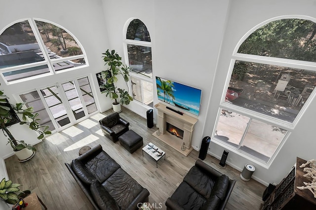 176 Saddlebow Rd, Bell Canyon, CA 91307 - living room with a lit fireplace, plenty of natural light, a high ceiling, and wood finished floors