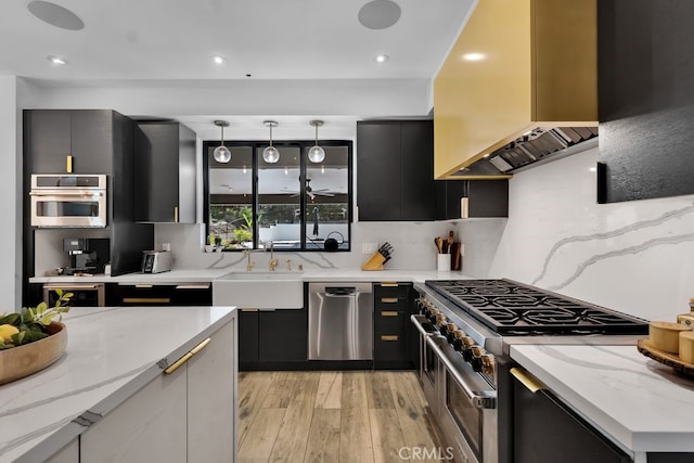 176 Saddlebow Rd, Bell Canyon, CA 91307 - kitchen featuring stainless steel appliances, premium range hood, dark cabinetry, light wood finished floors, and backsplash