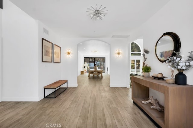 176 Saddlebow Rd, Bell Canyon, CA 91307 - hallway with arched walkways, light wood finished floors, and a chandelier
