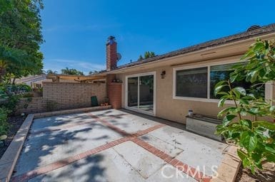14 Featherwood, Irvine, CA 92612 - back of property with a patio area, a fenced backyard, stucco siding, and a chimney