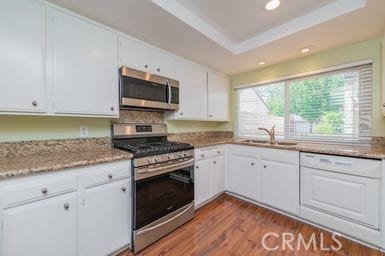 14 Featherwood, Irvine, CA 92612 - kitchen with stainless steel appliances, dark wood finished floors, white cabinets, recessed lighting, and light stone counters