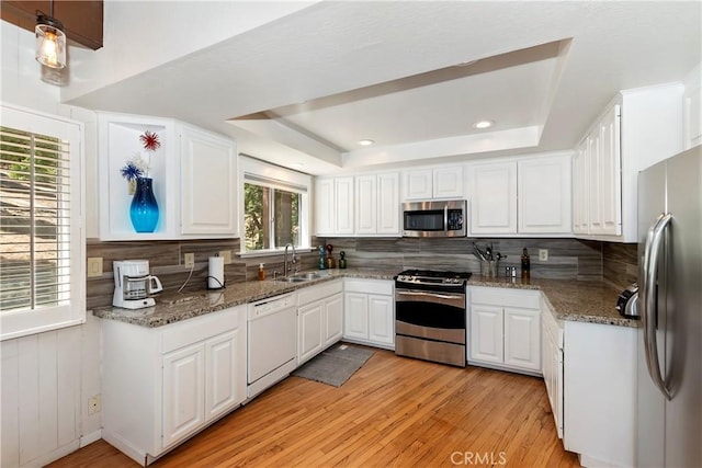544 Old Toll Rd, Lake Arrowhead, CA 92352 - kitchen with stainless steel appliances, a tray ceiling, tasteful backsplash, light wood-style floors, and white cabinetry