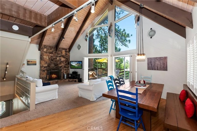 544 Old Toll Rd, Lake Arrowhead, CA 92352 - dining space featuring a wooden ceiling with exposed beams, wood-type flooring, high vaulted ceiling, a stone fireplace, and track lighting