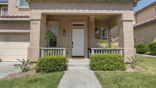 4058 Ivey Vista Way, Oceanside, CA 92057 - view of exterior entry with stucco siding, a porch, and a garage