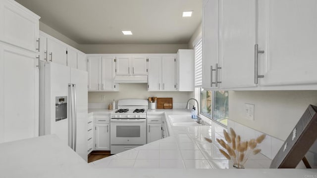 4058 Ivey Vista Way, Oceanside, CA 92057 - kitchen with white appliances, custom exhaust hood, white cabinets, and tile countertops