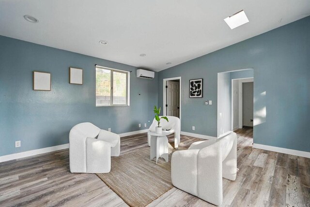 12049 Coping Pl, Lakeside, CA 92040 - living room with a wall mounted AC, wood finished floors, vaulted ceiling, and a skylight