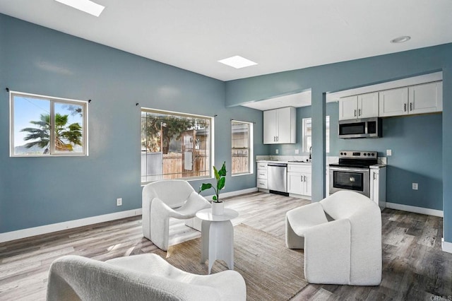 12049 Coping Pl, Lakeside, CA 92040 - living room with light wood-style floors and a skylight