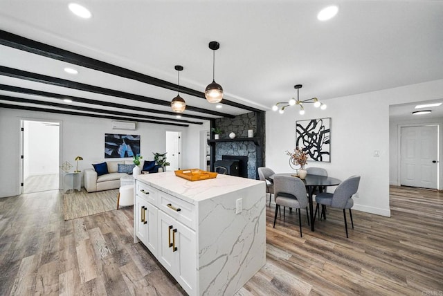12049 Coping Pl, Lakeside, CA 92040 - kitchen featuring a stone fireplace, open floor plan, white cabinetry, wood finished floors, and hanging light fixtures