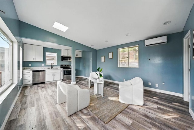 12049 Coping Pl, Lakeside, CA 92040 - living area with light wood-style floors, a wall mounted AC, healthy amount of natural light, and vaulted ceiling
