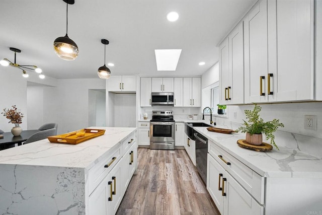 12049 Coping Pl, Lakeside, CA 92040 - kitchen with stainless steel appliances, light wood finished floors, recessed lighting, white cabinetry, and a skylight