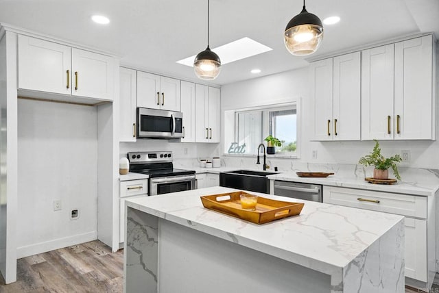 12049 Coping Pl, Lakeside, CA 92040 - kitchen featuring appliances with stainless steel finishes, a skylight, white cabinets, light stone counters, and recessed lighting