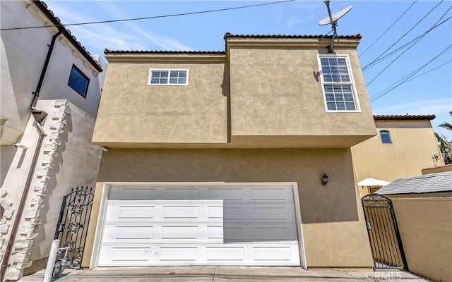 218 Covina Ave, Long Beach, CA 90803 - rear view of property featuring a garage, stucco siding, and a gate