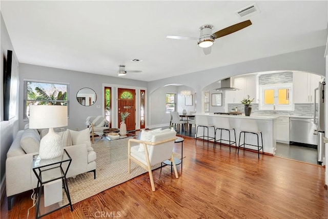 218 Covina Ave, Long Beach, CA 90803 - living room featuring arched walkways, ceiling fan, and wood finished floors