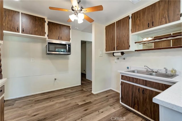 13925 Belgate St, Baldwin Park, CA 91706 - kitchen with stainless steel microwave, ceiling fan, light countertops, light wood-type flooring, and open shelves