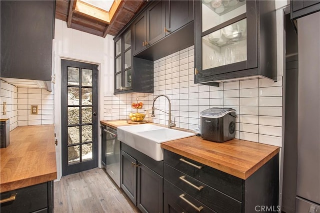 1551 N Beverly Glen Blvd, Los Angeles, CA 90077 - kitchen with butcher block countertops, decorative backsplash, stainless steel dishwasher, and light wood-style floors