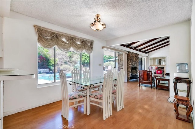 211 Peacock Ln, Montebello, CA 90640 - dining room with light wood-type flooring, a textured ceiling, and a fireplace