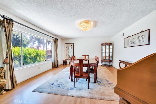 211 Peacock Ln, Montebello, CA 90640 - dining area featuring a textured ceiling and light wood-style flooring