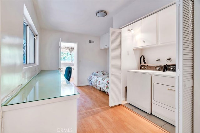 211 Peacock Ln, Montebello, CA 90640 - laundry room with separate washer and dryer, light wood-style floors, and cabinet space