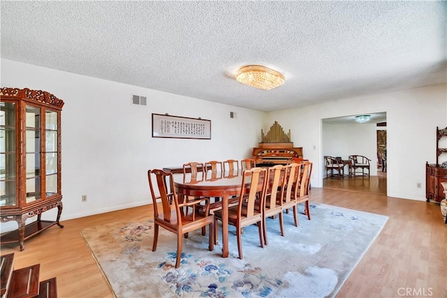 211 Peacock Ln, Montebello, CA 90640 - dining area featuring a textured ceiling and wood finished floors