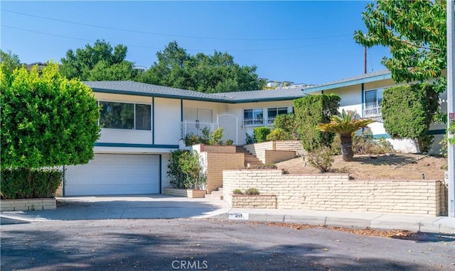211 Peacock Ln, Montebello, CA 90640 - view of front facade with stucco siding, stairway, driveway, and a garage