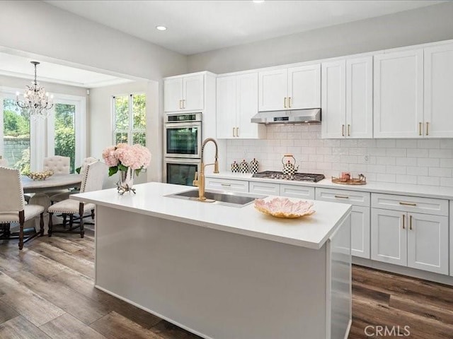 23808 Bayview Ct, Valencia, CA 91355 - kitchen with appliances with stainless steel finishes, light countertops, a chandelier, dark wood finished floors, and recessed lighting