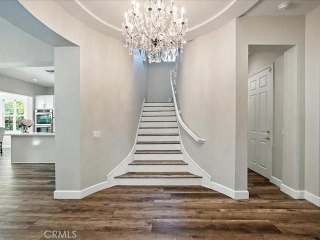 23808 Bayview Ct, Valencia, CA 91355 - stairs featuring wood finished floors, a chandelier, and a raised ceiling