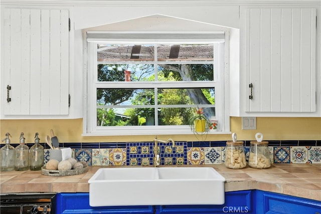 1215 S Patton Ave, San Pedro, CA 90731 - kitchen view of blue cabinetry, tile countertops, white cabinets, and tasteful backsplash