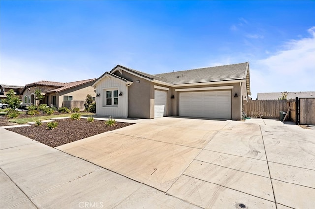 2070 Solig Ave, Kingsburg, CA 93631 - view of front of house featuring a garage, a tile roof, stucco siding, and driveway