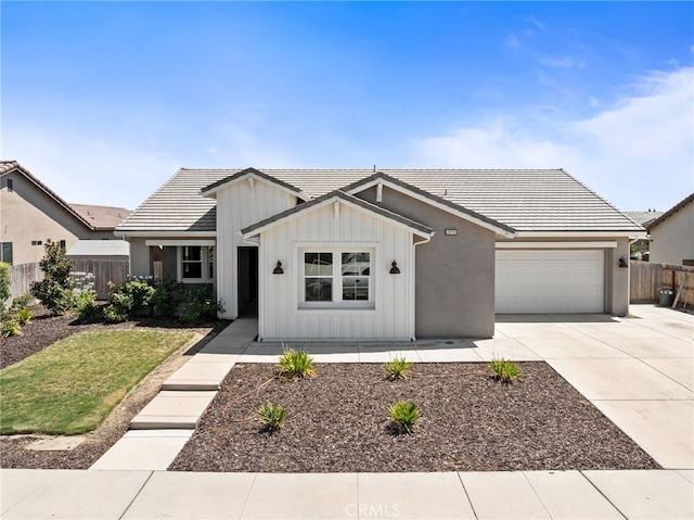 2070 Solig Ave, Kingsburg, CA 93631 - modern farmhouse style home with concrete driveway, an attached garage, a tile roof, and board and batten siding