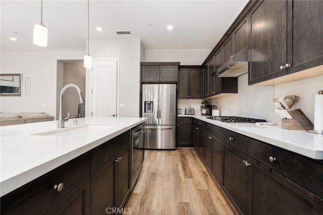 2070 Solig Ave, Kingsburg, CA 93631 - kitchen with stainless steel appliances, light wood-style flooring, light countertops, dark brown cabinetry, and pendant lighting