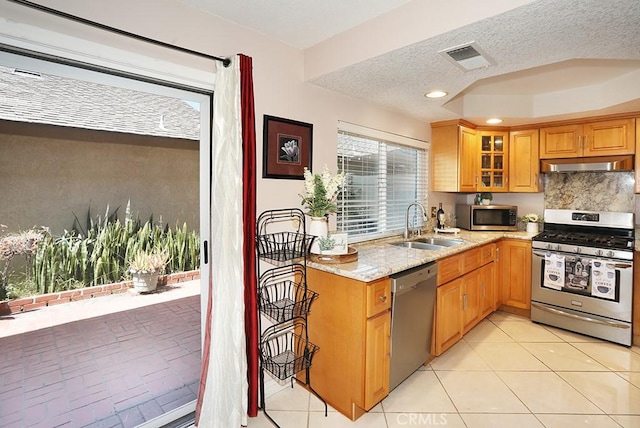 1201 W Cerritos Ave Unit 68, Anaheim, CA 92802 - kitchen featuring stainless steel appliances, under cabinet range hood, light stone countertops, glass insert cabinets, and tasteful backsplash