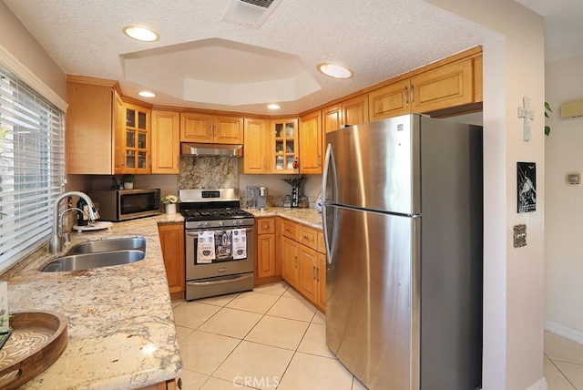 1201 W Cerritos Ave Unit 68, Anaheim, CA 92802 - kitchen with stainless steel appliances, under cabinet range hood, a tray ceiling, light stone counters, and a textured ceiling