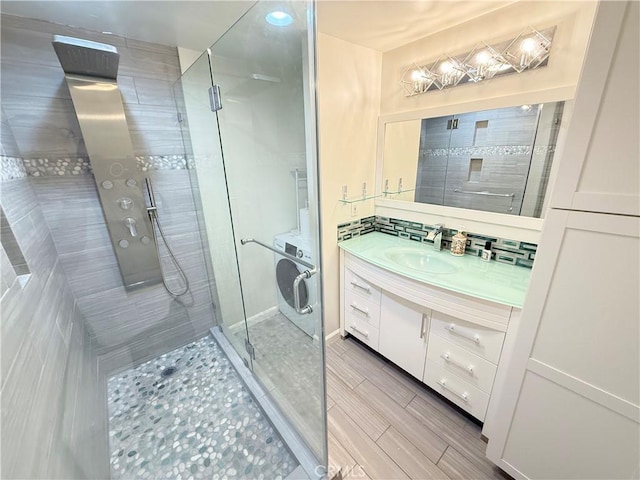 1126 N Central Ave Unit 303, Glendale, CA 91202 - bathroom featuring a shower stall, vanity, wood finish floors, and washer / clothes dryer