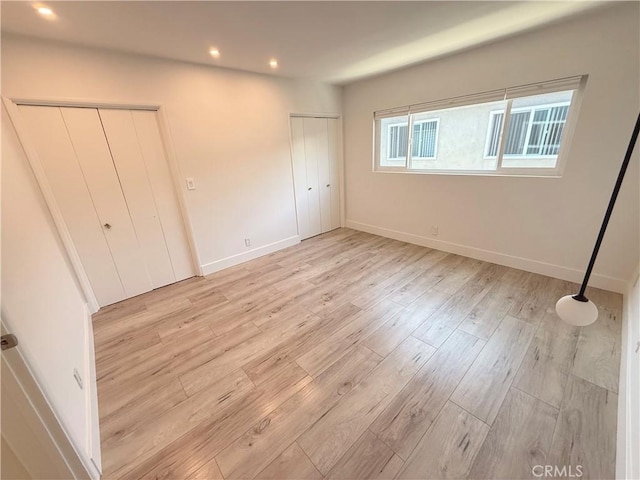 1126 N Central Ave Unit 303, Glendale, CA 91202 - unfurnished bedroom featuring two closets, light wood finished floors, and recessed lighting