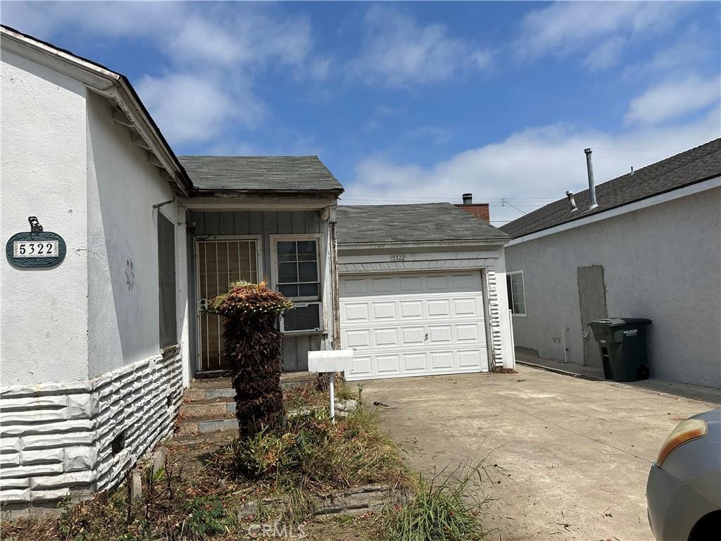 5322 Pearce Ave, Lakewood, CA 90712 - view of side of property featuring driveway, an attached garage, and stucco siding