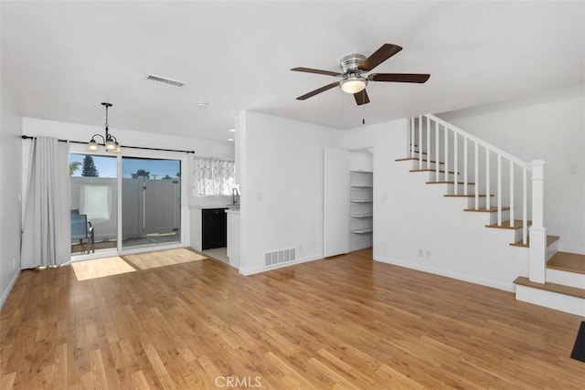 17695 Brittany Ln Unit 74, Huntington Beach, CA 92647 - unfurnished living room with stairs, a ceiling fan, light wood finished floors, and a chandelier