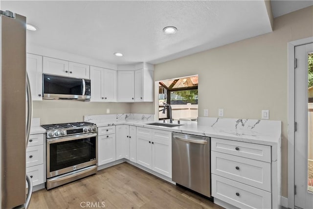 26337 Rainbow Glen Dr Unit 244, Newhall, CA 91321 - kitchen featuring stainless steel appliances, healthy amount of natural light, white cabinets, and recessed lighting