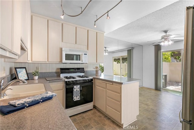 810 E Laurel Oak Dr, Azusa, CA 91702 - kitchen with gas range oven, white microwave, a peninsula, a ceiling fan, and cream cabinetry