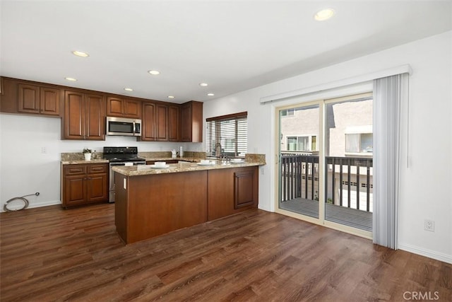 10 Starfall Unit 11, Irvine, CA 92603 - kitchen with stainless steel appliances, dark wood-type flooring, a peninsula, light stone counters, and recessed lighting