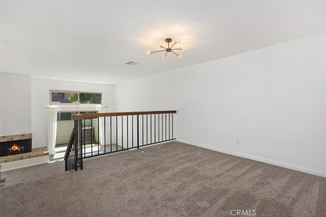 10 Starfall Unit 11, Irvine, CA 92603 - unfurnished room with carpet flooring, a chandelier, and a fireplace