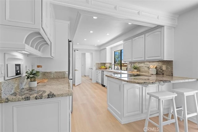 21 Santa Catalina Dr, Rancho Palos Verdes, CA 90275 - kitchen with a peninsula, black electric cooktop, light wood-style flooring, backsplash, and light stone countertops