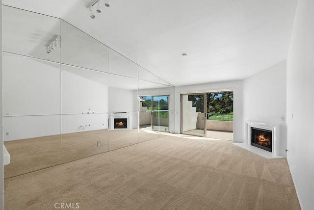 232 Villa Point Dr, Newport Beach, CA 92660 - unfurnished living room with a lit fireplace, carpet floors, and rail lighting