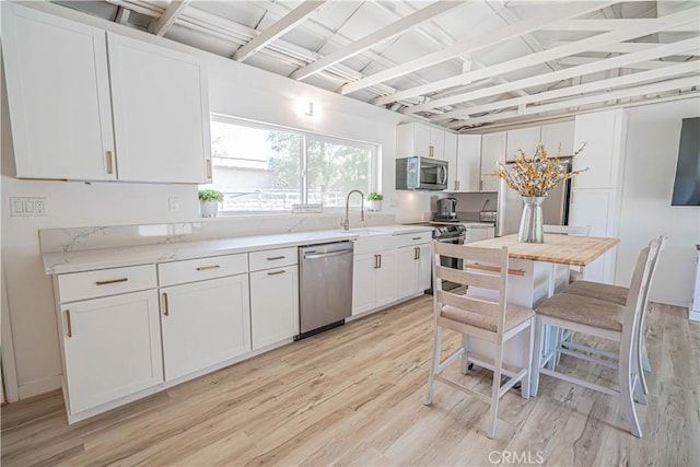 35356 Sierra Vista Dr, Agua Dulce, CA 91390 - kitchen featuring appliances with stainless steel finishes, light wood-type flooring, white cabinets, and light stone countertops