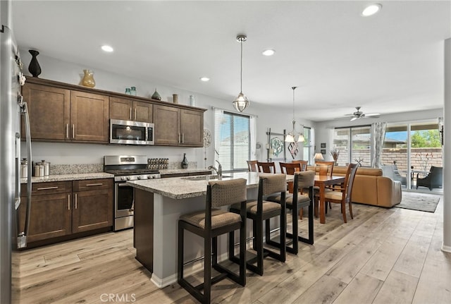 1616 Rosemary, Beaumont, CA 92223 - kitchen featuring appliances with stainless steel finishes, healthy amount of natural light, dark brown cabinets, a breakfast bar area, and recessed lighting