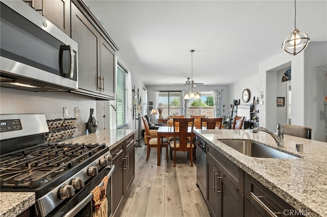 1616 Rosemary, Beaumont, CA 92223 - kitchen with appliances with stainless steel finishes, light wood-style floors, decorative light fixtures, and light stone counters