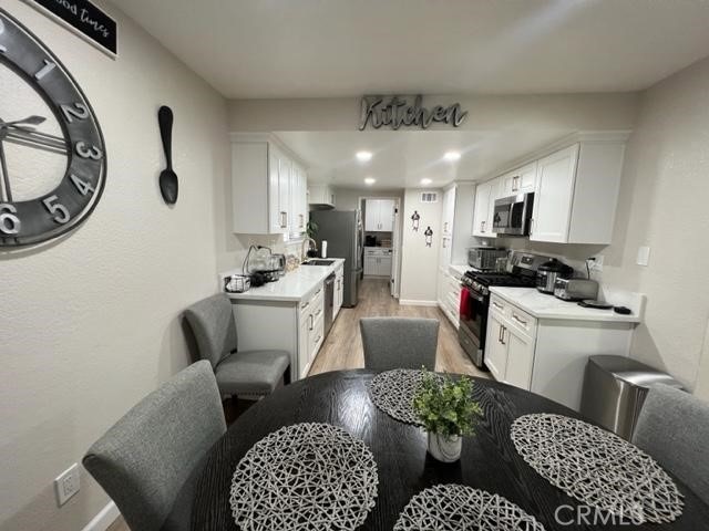 9827 Estacia Ct, Rancho Cucamonga, CA 91730 - kitchen featuring stainless steel appliances, light wood-type flooring, white cabinetry, light countertops, and recessed lighting