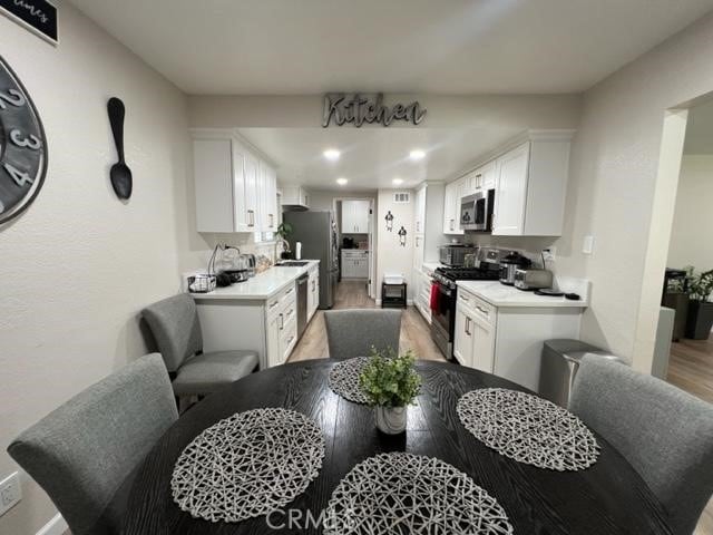 9827 Estacia Ct, Rancho Cucamonga, CA 91730 - kitchen with appliances with stainless steel finishes, light wood-style flooring, light countertops, white cabinets, and recessed lighting